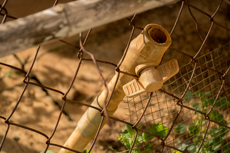 Close-up Dirty PVC Valve/ Plastic Pipe - Rusty Old Wire Fence - Abandoned Junkの写真素材
