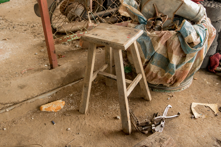 Old Rustic Stool Chair in Messy Garage - Vintage House. Toolsの写真素材