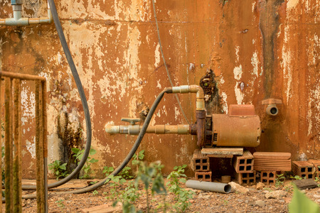 Dirty Old PVC Valve/ Plastic Water Pipeline - Vintage Moldy Wall Texture. Abandoned Garden. Yellow Warm Toneの写真素材