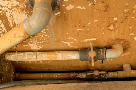 Dirty Old PVC Valve/ Plastic Water Pipeline - Vintage Moldy Wall Texture. Abandoned Garden. Yellow Warm Toneの写真素材