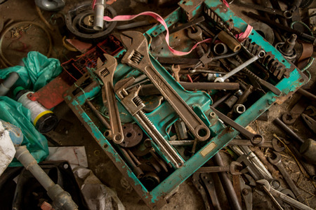 Greasy Tools on Dirty Concrete Floor. Messy Garage