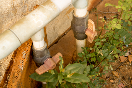 Dirty Old PVC Valve/ Plastic Water Pipeline - Vintage Moldy Wall Texture. Abandoned Garden. Yellow Warm Toneの写真素材
