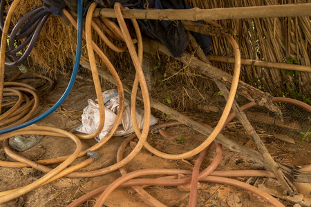 Vintage Old Hosepipe on Dirty Concrete Ground - Abandoned Chicken Coop. Messy Toolsの写真素材