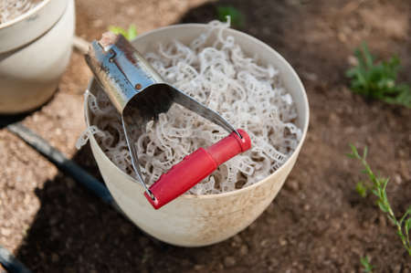 A container of ties used to secure plantings on supports along with a hand seedling transplanting shovel.の写真素材