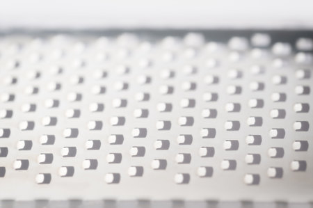 Repeating background of squares created from a close-up view of a metal grater.の写真素材