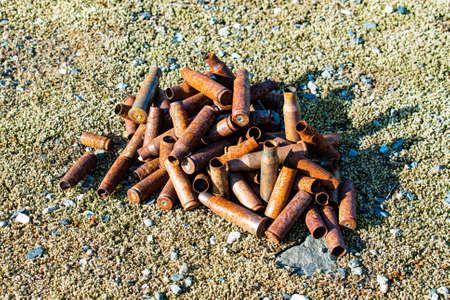 Pile of old rusty shell casings on the sandの写真素材
