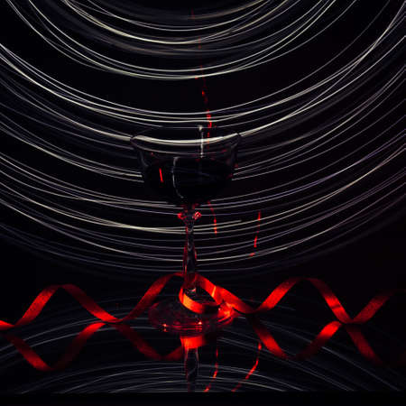 Wine glass, with lines of lights in the background.の写真素材