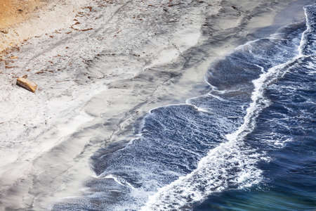 Blue waves on dirty sand, sea foam, copy paste, Paracas, Peruの写真素材