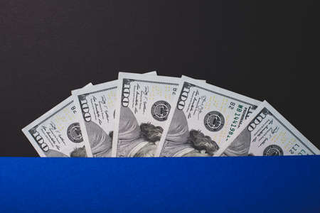 A lot of dollars close-up in a semicircle on a black background.の写真素材