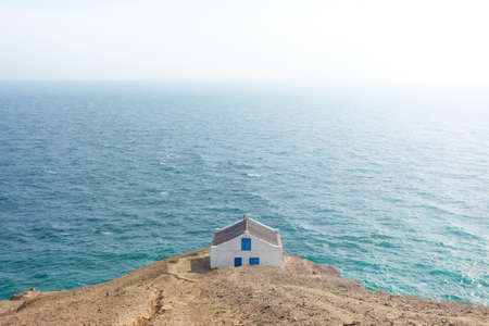 Lonely stone house on the edge of a cliff with sea viewsの写真素材