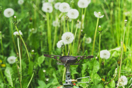 Small tourist gas burner with gas balloon in the grass trekking and hiking concept.の写真素材