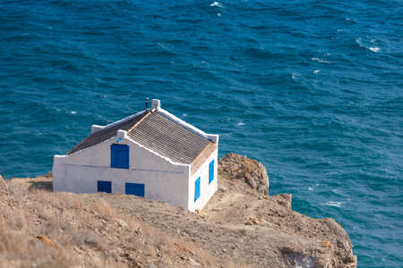 House on the edge of a cliff overlooking the seaの写真素材