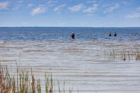 Three fishermen spinning fish in the water in the Kiev Sea, Ukraine 2020-05-03.のeditorial素材