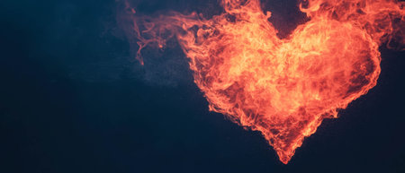 Fire heart shape glowing in red against a deep black background for romantic themesの写真素材