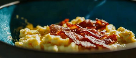 Fluffy scrambled eggs topped with crispy bacon bits for a delightful breakfast experienceの写真素材