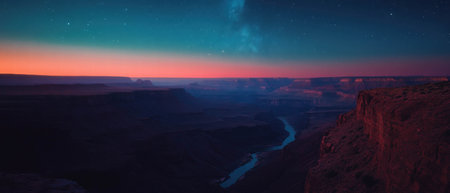 Night sky over a vast canyon illuminated by countless stars and a soft glow on the horizonの素材