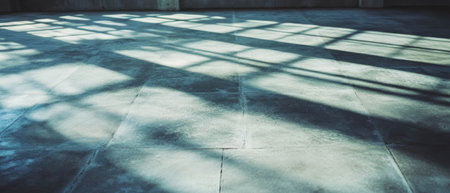 Concrete tiles with smooth surface and industrial backdrop featuring light patternsの写真素材