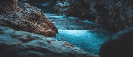 Mysterious underground river flows through dark cave with hidden blue watersの素材