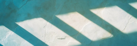 Venetian plaster surface with rough texture and long casting shadows in bright lightの素材