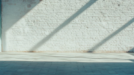 Sunlight casting shadows on textured white brick wall surfaceの素材