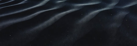 Captivating texture of fine black sand with gentle ripples under soft lightの素材