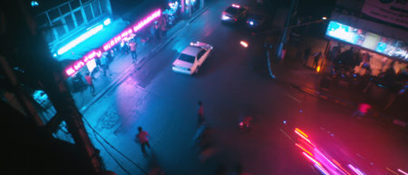 Nighttime urban traffic flows along busy highway with vivid light trailsの素材