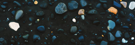 Black sand with pumice stones showcases natural textures and colors on the shoreの素材