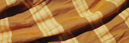 Brown plaid tablecloth texture displaying intersecting lines in a rustic settingの素材