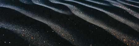 Texture of black sand with windblown patterns under soft lighting creates serene ambianceの素材