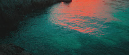 Cinematic view of a tranquil river delta at sunset showcasing vibrant color contrastsの素材