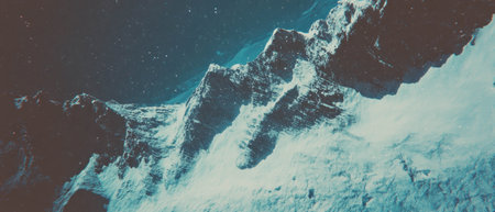 Cinematic view of a majestic snow-covered mountain range from above with vivid contrasts