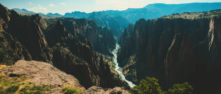 Dramatic canyon landscape with a winding river in the foreground and mountains in the backgroundの写真素材
