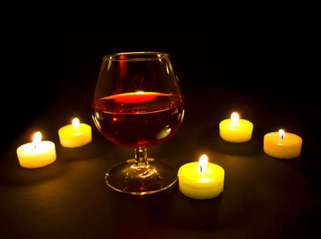 wineglass with red wine at candlelightの写真素材