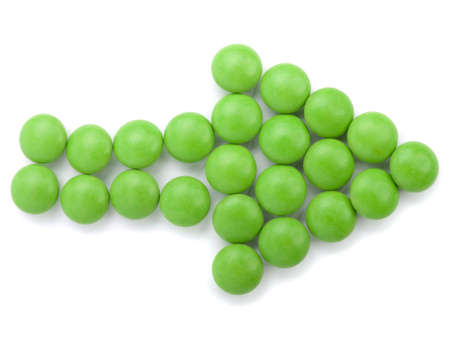 green tablets in arrow formation, isolated on white background の写真素材