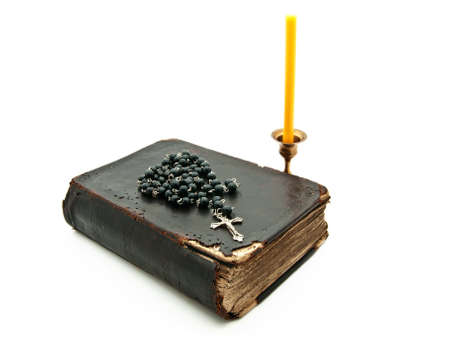 candle in bronze candlestick, rosary and old book on white background の写真素材