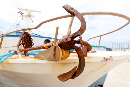 Closeup of old metal anchor on fishing boatの写真素材