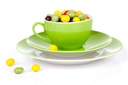 green cup with colorful candies, on white backgroundの写真素材