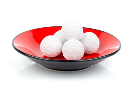 praline on red bowl, on white background