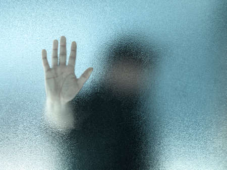 Silhouette of a man through frosted glass