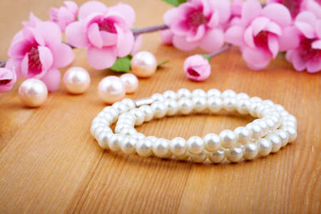 pearl bangles, with pink flower on wooden backgroundの写真素材
