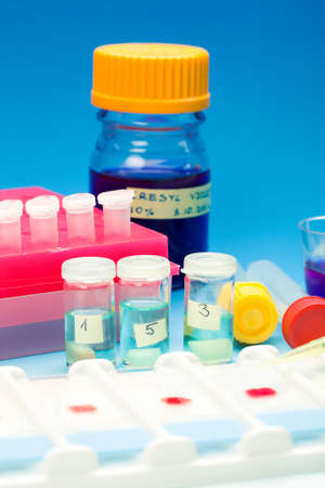 Array of blood samples for microscopy and biopsy tissue on blue gradient background