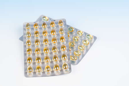 fish oil capsules and blister pack isolated  on blue background.