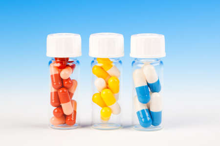 Colorful medical capsules in bottle, on blue background.の写真素材