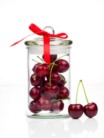 fresh Sweet cherry in glass jar, isolated on whiteの写真素材