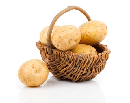 Golden Potatoes in wicker basket over white backgroundの写真素材