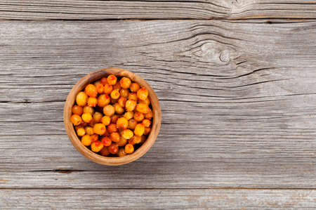frozen Sea-buckthorn berries on the wooden backgroundの写真素材