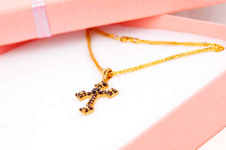 Golden Cross with garnets in packagedの写真素材