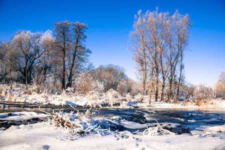 winter landscape of snow-covered trees and river in winter season, Germany