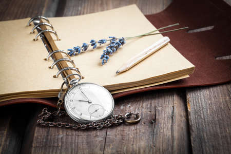 Vintage grunge still life with pocket watch, lavender flower and old book.の写真素材