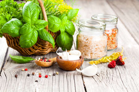 spices: garlic, salt, pepper and basil on a wooden backgroundの写真素材